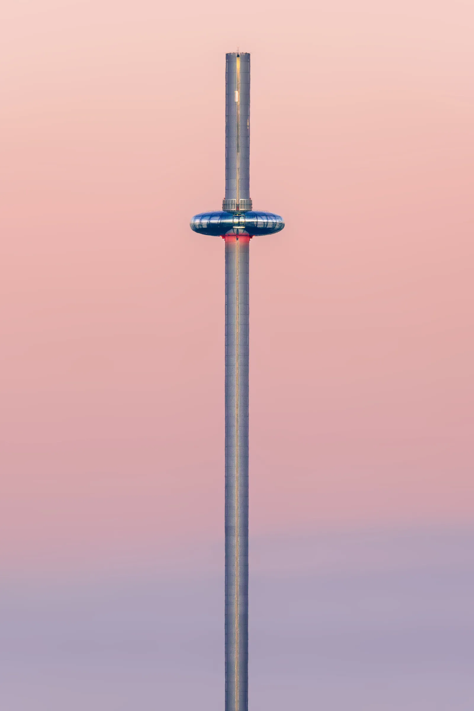 Brighton i360 tower centred against a soft pastel sky, with the observation pod mid-ascent in a minimal composition.