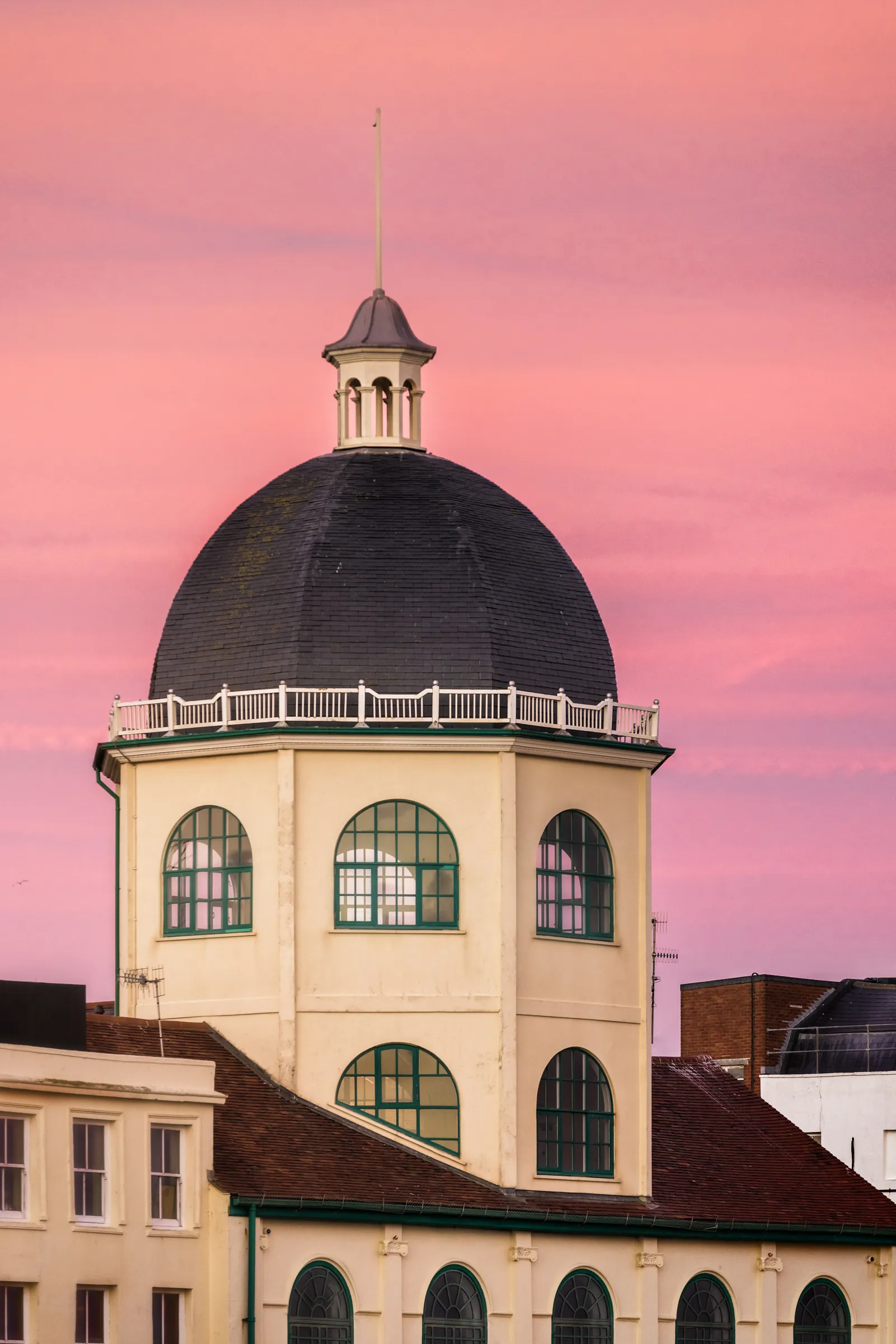 The dome of Worthing Dome Cinema framed against a soft pink sky, with clean architectural lines and minimal composition.
