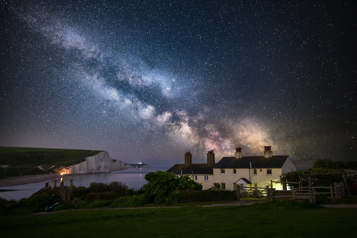 The Milky Way arching over the Coastguard Cottages at Cuckmere Haven