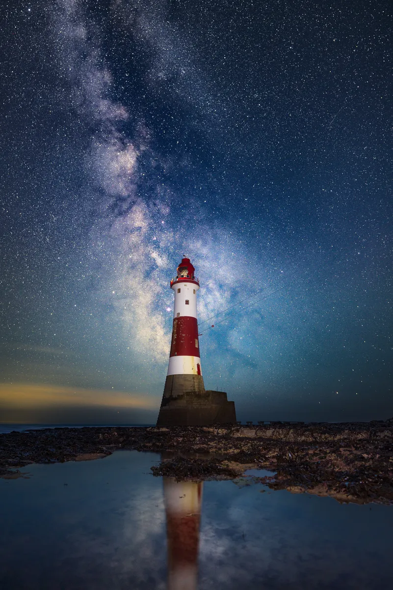 The Milky Way rising behind Beachy Head Lighthouse reflected in a tidal pool on the Sussex coast