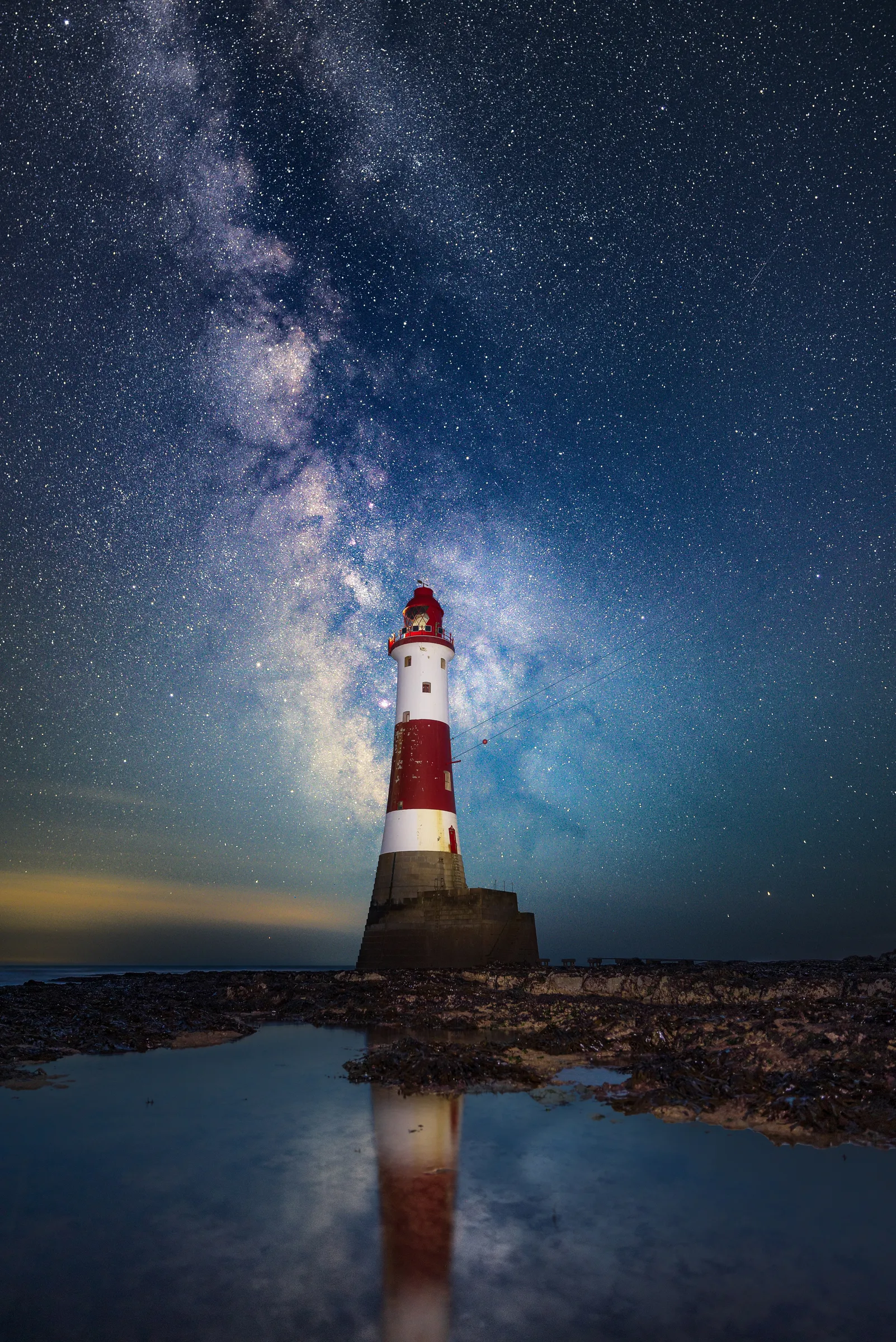 The Milky Way rising behind Beachy Head Lighthouse reflected in a tidal pool on the Sussex coast